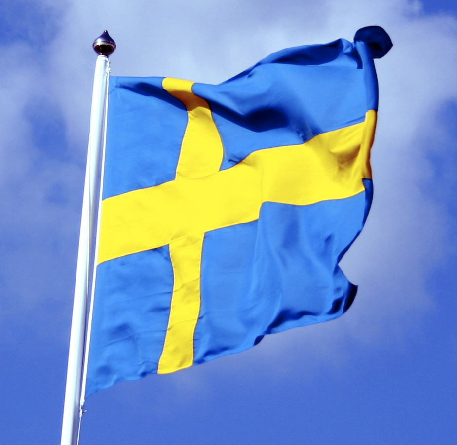 Swedish flag with blue sky behind commons.wikimedia